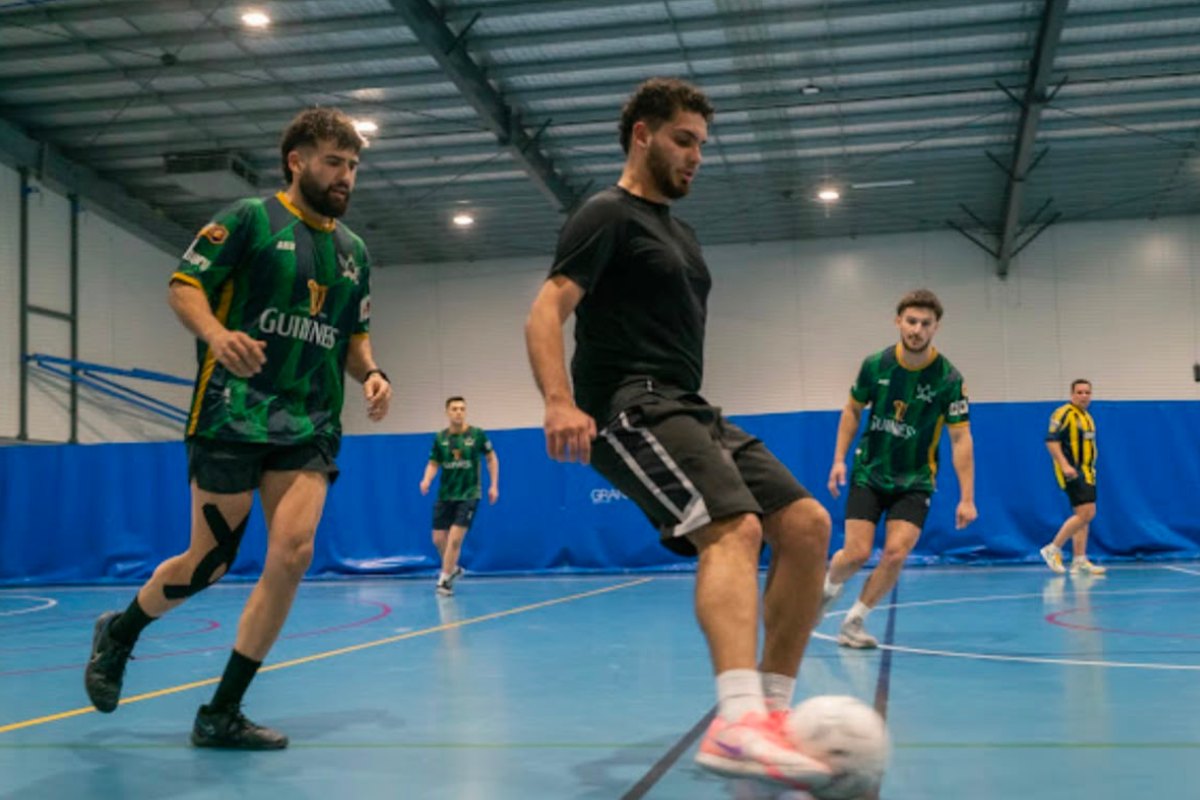 Players competing for the ball in a fast 5-a-side futsal match